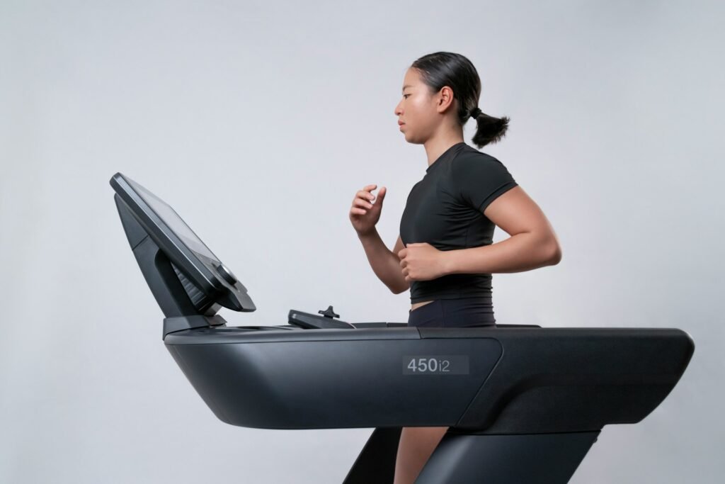 Side view of fit, young woman running on a treadmill
