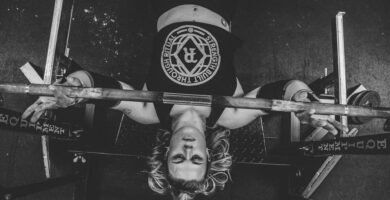 black and white photo of woman getting ready to perform a bench press exercise