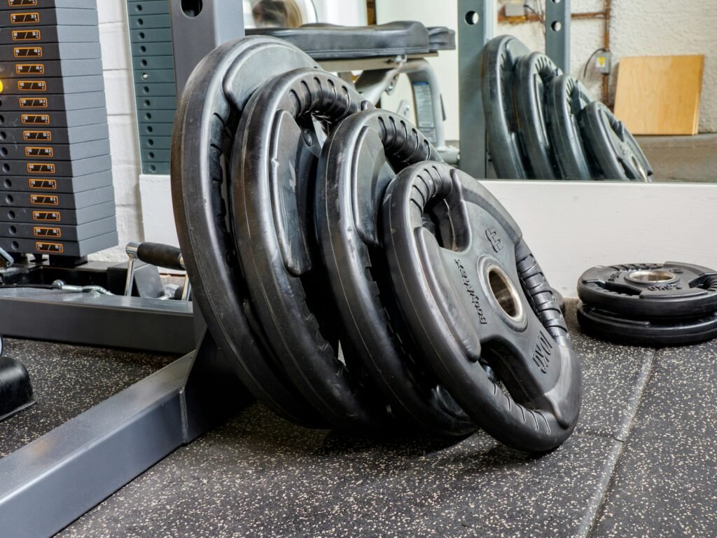 set of black weight plates leaning against a gym machine