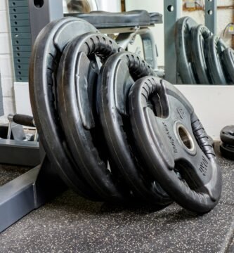 set of black weight plates leaning against a gym machine
