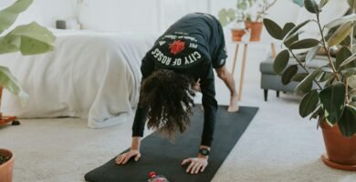 woman is doing a yoga pose on a mat